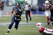 Seattle Seahawks quarterback Russell Wilson running by Arizona Cardinals defenders